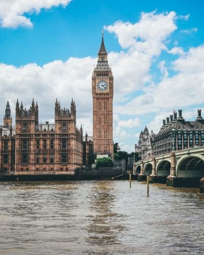 Beautiful view of Big Ben and River Thames under a blue sky in London, England.